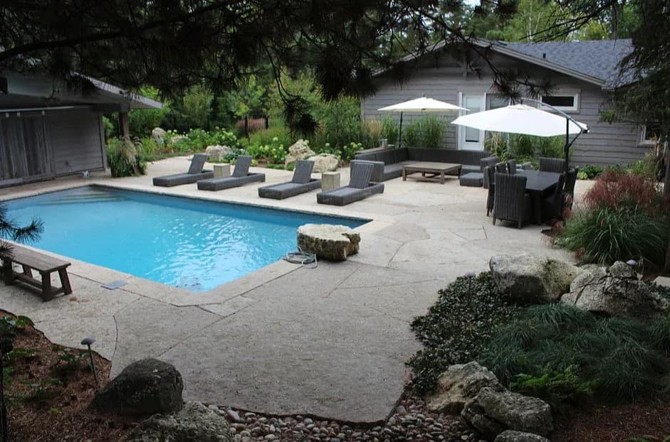 Swimming pool framed by an irregular flagstone patio in Collingwood, Ontario